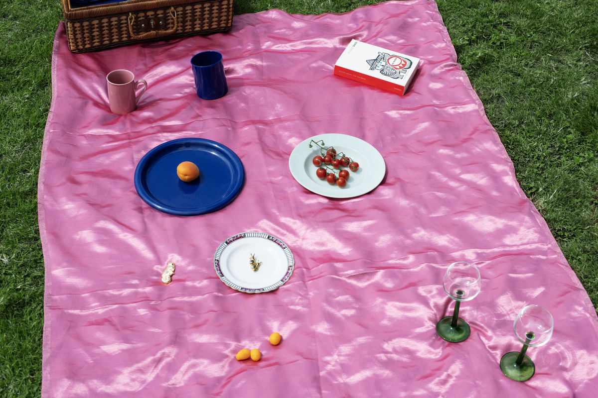 A picnic on a pink picnic blanket.